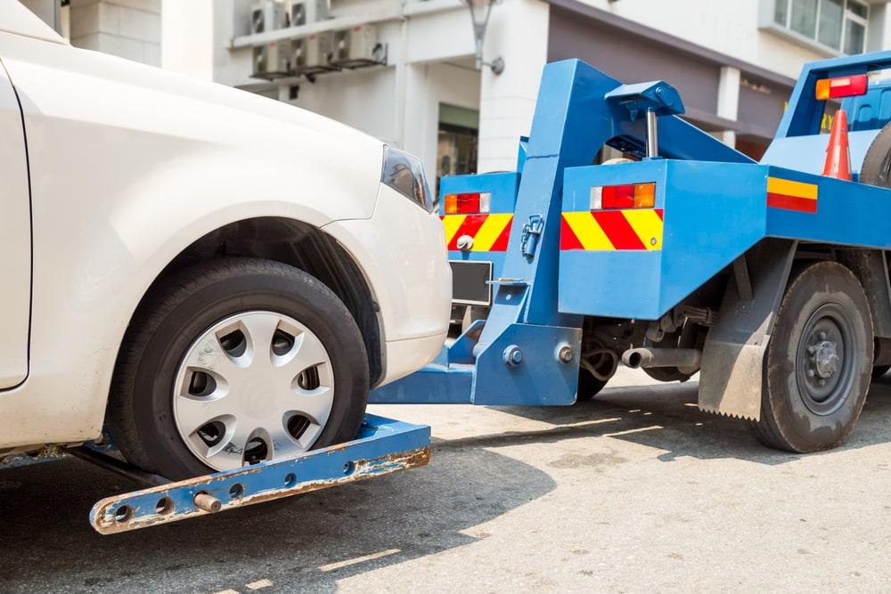 White Car Being Lifted On A Tow Truck